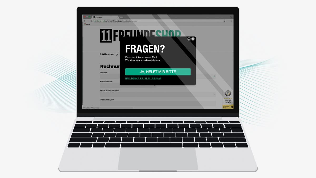 Macbook mit der Website von 11Freunde auf dem Bildschirm geöffnet. Auf der Website erscheint ein Service Popup mit der Überschrift: Fragen?