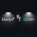 Zwei beleuchtete Logos stehen sich gegenüber: links 'klaviyo', rechts 'uptain', getrennt durch ein zentrales 'VS'. Darunter steht der Text: Unterschied zwischen Klaviyo und uptain Basteln oder automatisieren?