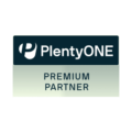 Ein rechteckiges Logo mit dunklem oberen Bereich und hellem, leicht grünlichem unteren Bereich. Oben steht „PlentyONE“ mit einem stilisierten „P“-Symbol links daneben. Darunter der Text „PREMIUM PARTNER“ in Großbuchstaben.