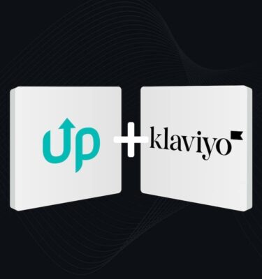 Zwei dreidimensionale quadratische Kacheln auf dunklem Hintergrund mit abstrakten Wellenlinien. Linke Kachel zeigt das türkisfarbene 'up' Logo mit Pfeil nach oben, rechte Kachel das schwarze Klaviyo Logo. Zwischen den Kacheln ein weißes Pluszeichen. 